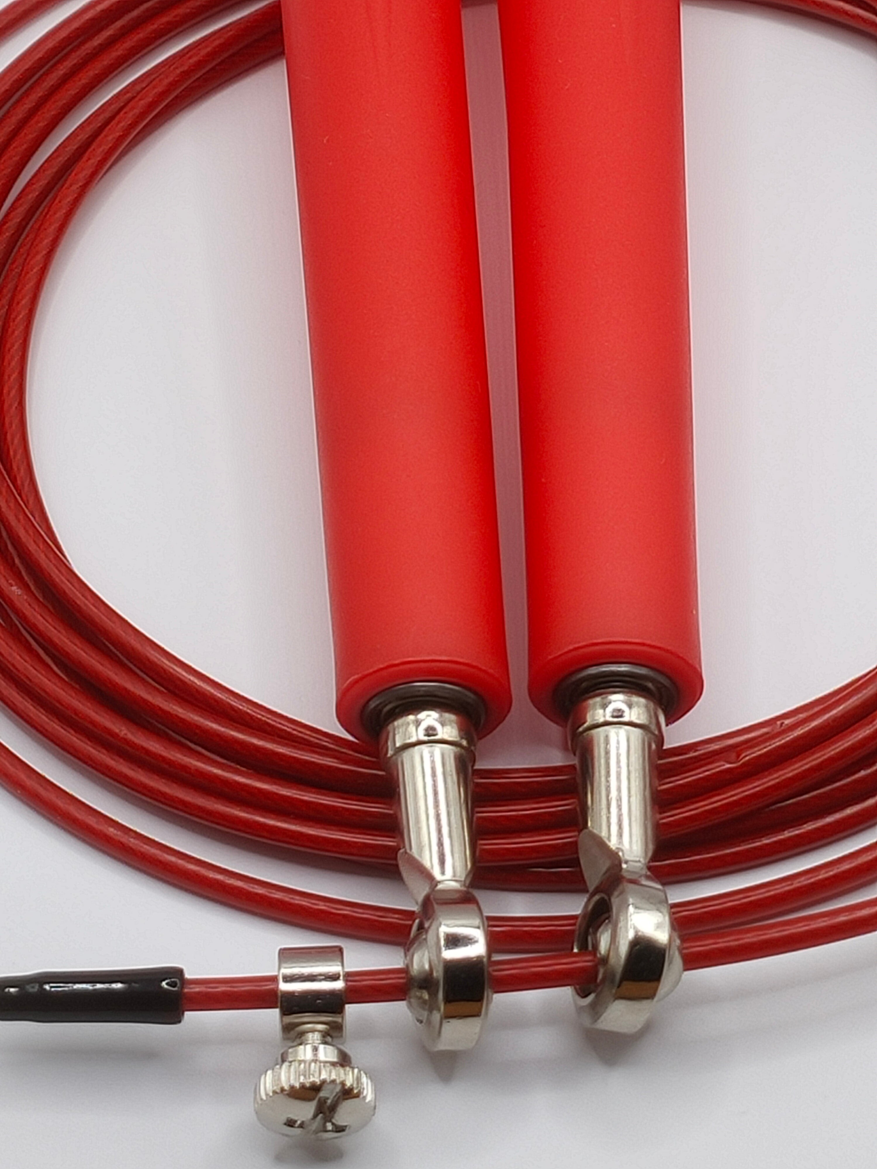 Close-up van de stalen kabel met PVC-coating van het speed rope rode springtouw
